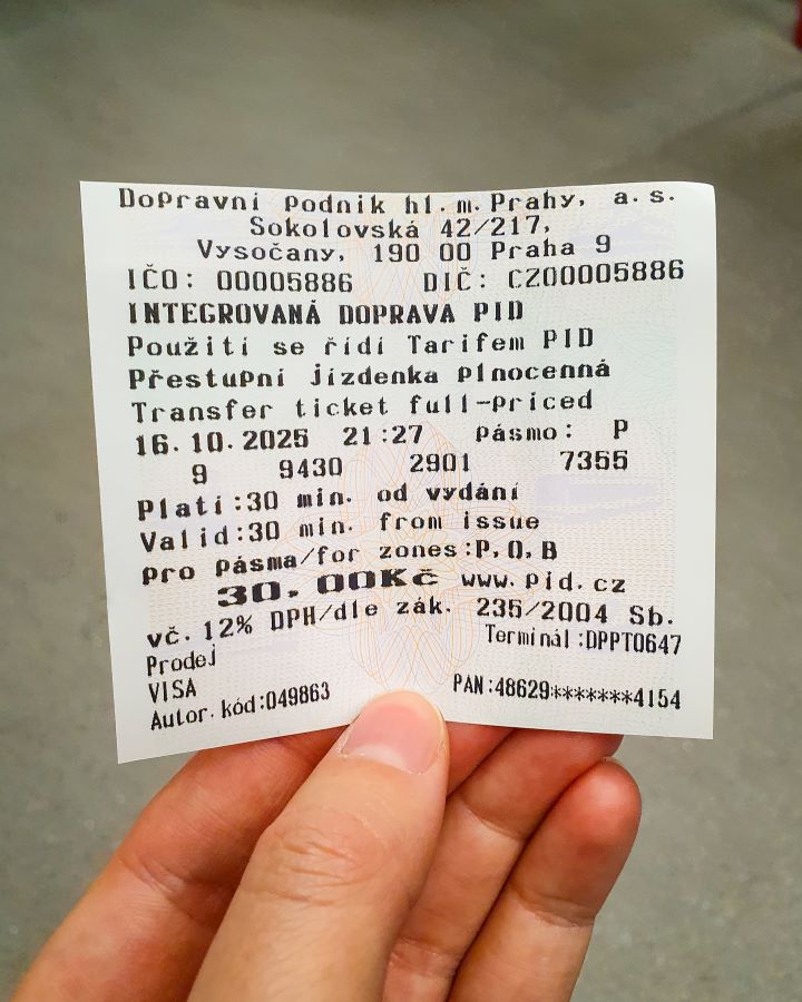 Prague Czechia A Complete Guide to Prague Public Transport A hand holding a white ticket with black writing which is a tram ticket from a machine on a tram in Prague, Czechia. A Complete Guide to Prague Public Transport