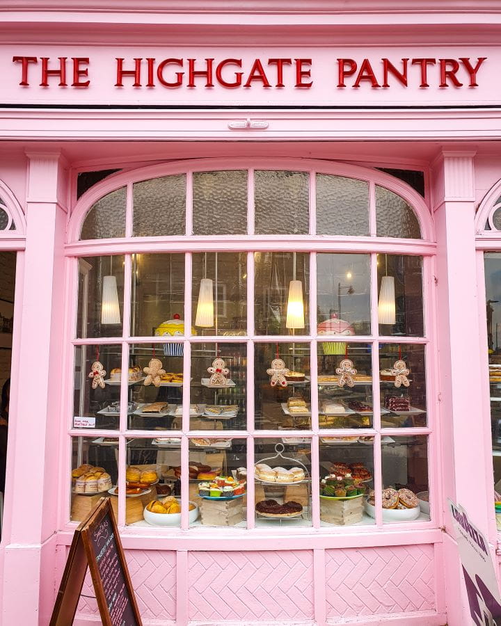 Highgate High Street London Less Touristy Places in London for Return Visitors A pink shop front that says "The Highgate Pantry" with lots of cakes in the window on Highgate High Street in London. There's also little gingerbread men hanging up with some lights and a sign out the front. Less Touristy Places in London for Return Visitors