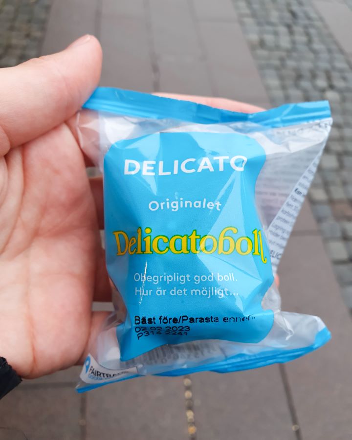Sweden How To Have The Best Day In Malmö From Copenhagen A hand holding a blue packet that says "delicatoboll" on it in Malmö, Sweden. How To Have The Best Day In Malmö From Copenhagen