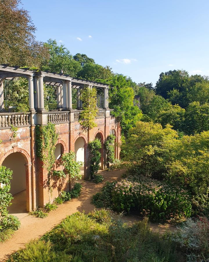 United Kingdom The Hill Garden and Pergola Nine Less Touristy But Wonderful Parks to Visit in London The Hill Garden and Pergola in London. There's a brick pergola on the left with archways and a walkway above. There's a path below with lots of plants and trees around. Nine Less Touristy But Wonderful Parks to Visit in London